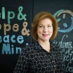 woman smiling standing in front of chalkboard