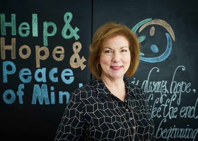 woman smiling standing in front of chalkboard