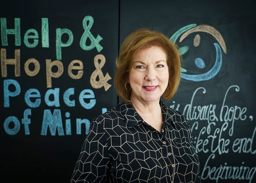 woman smiling standing in front of chalkboard