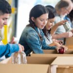 volunteers sorting food donations into boxes