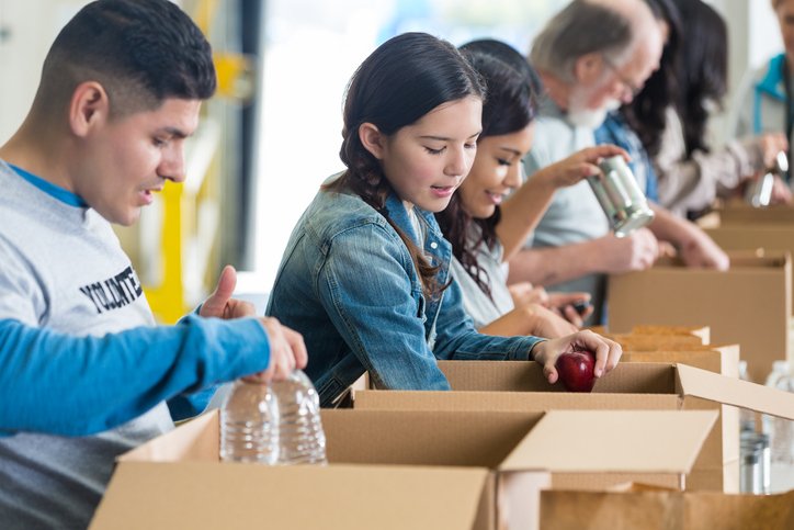 volunteers sorting food donations into boxes